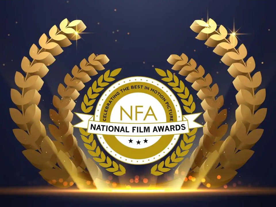 A promotional image for the National Film Awards featuring a gold laurel wreath encircling a white and gold badge with the letters “NFA” and the tagline “Celebrating the Best in Motion Picture”.